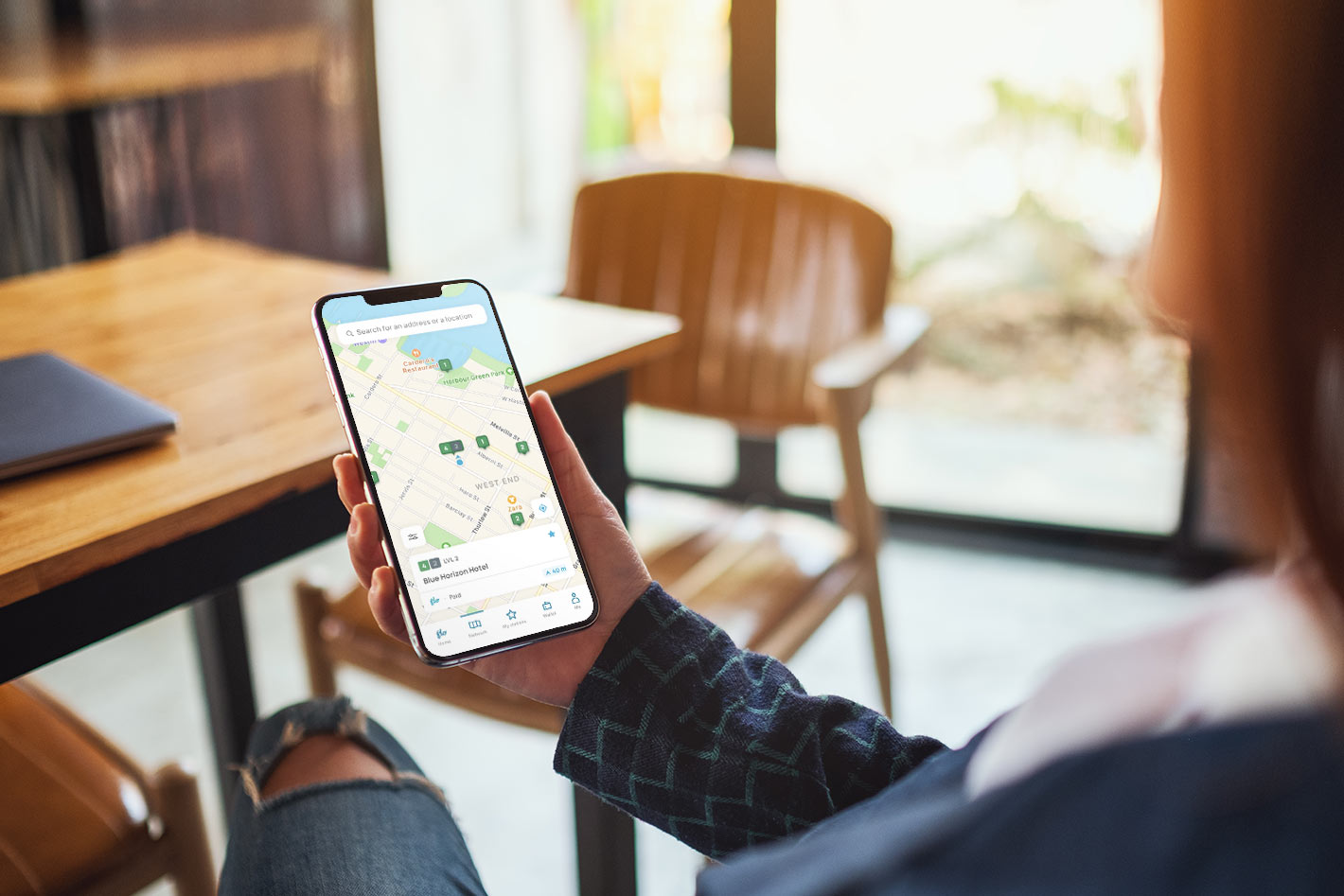 A user holding a smarhtphone with the Flo Home Smartphone App open