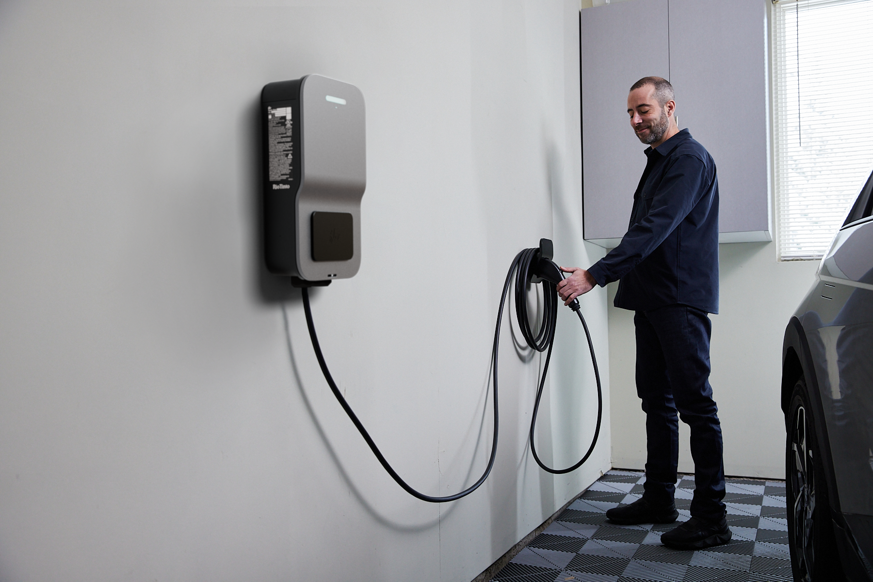 Silver FLO Home X6 EV charger installed indoor in a car garage with a detachable charging connector