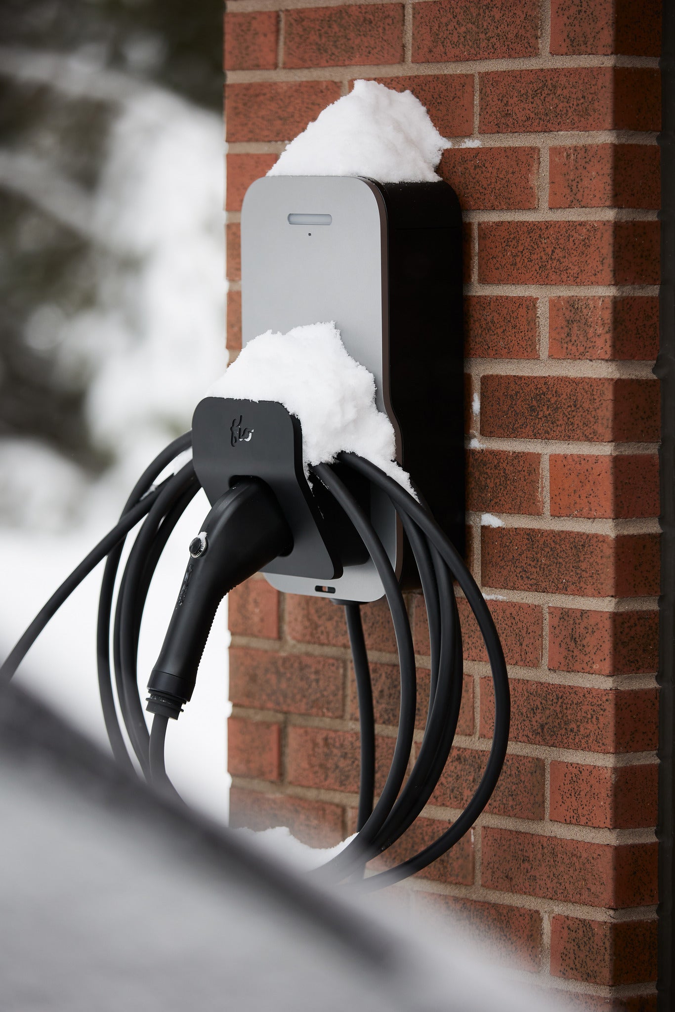 Silver FLO Home X6 EV charger installed on the side wall off a house 