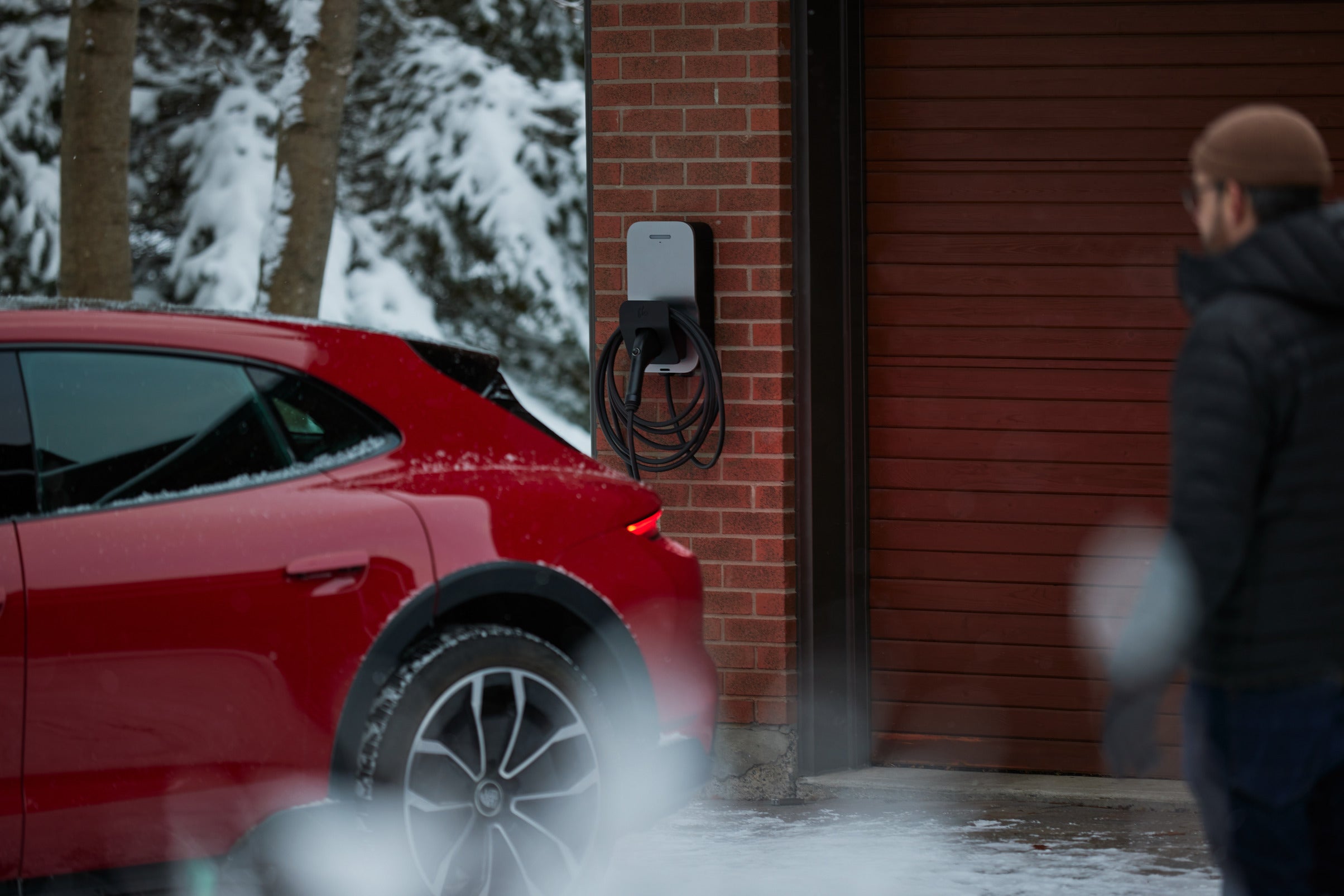 User finishing charging a red electric vehicle with a FLO Maison X6 charging station