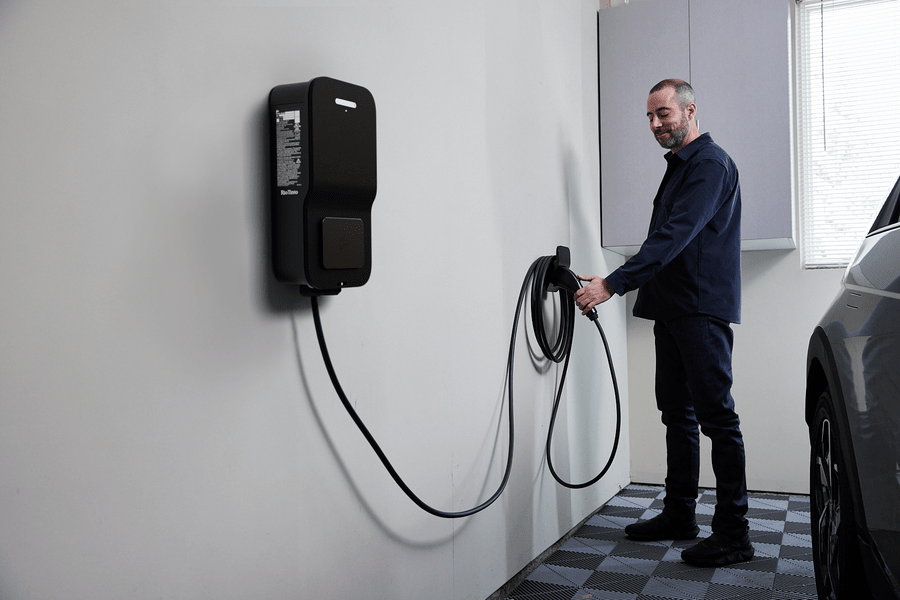 FLo Home Black X8 EV charging stations, indoor installation, with a detachable set up in use by a men next to his EV car