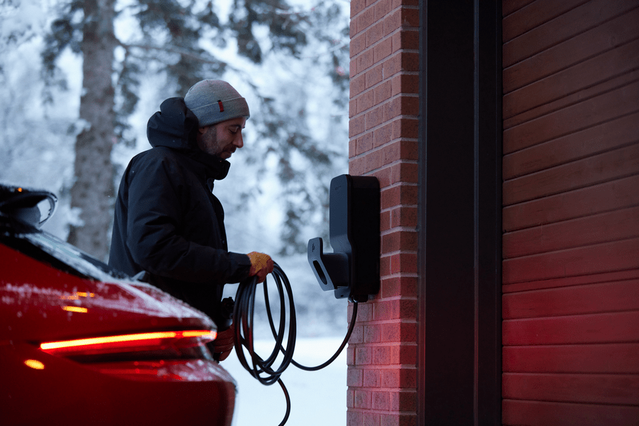 Flo Home Black Residential X8 EV charging stations, outdoor installation, men charging red car in winter